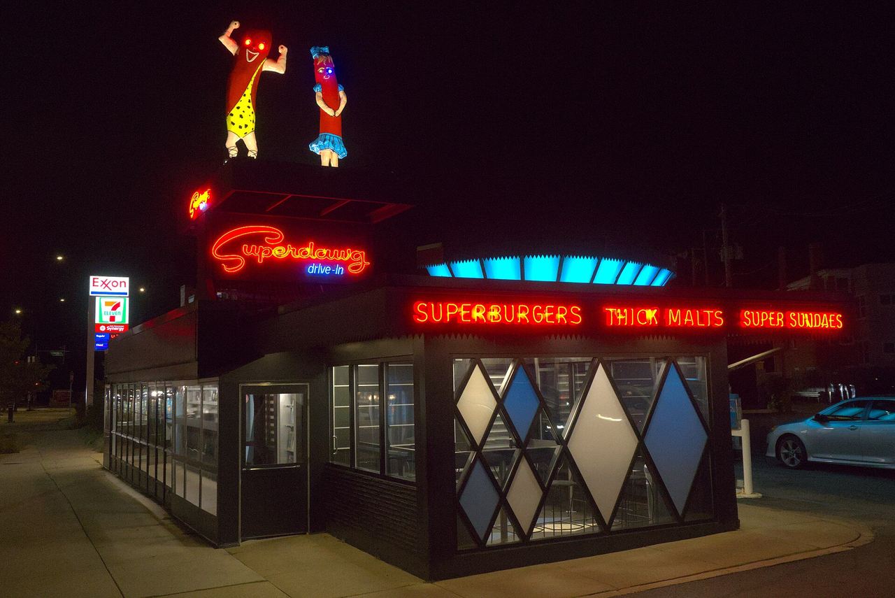 Superdawg’s drive-in and rooftop figures at night.